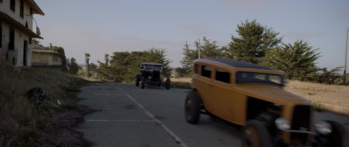 Antique vintage cars driving down a road