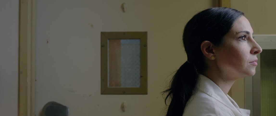 Female doctor stands still in a room