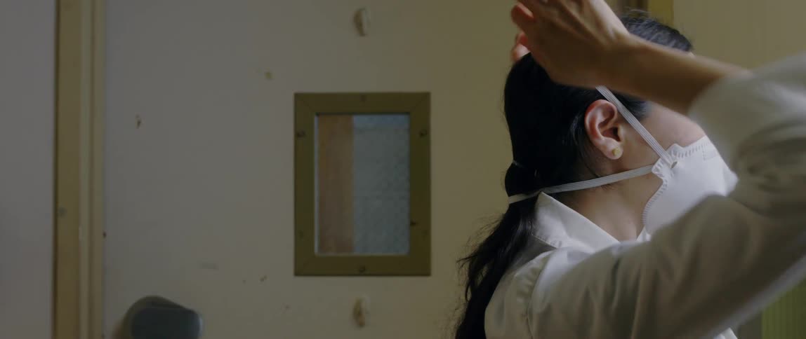 Female doctor in a clinic puts a face mask on