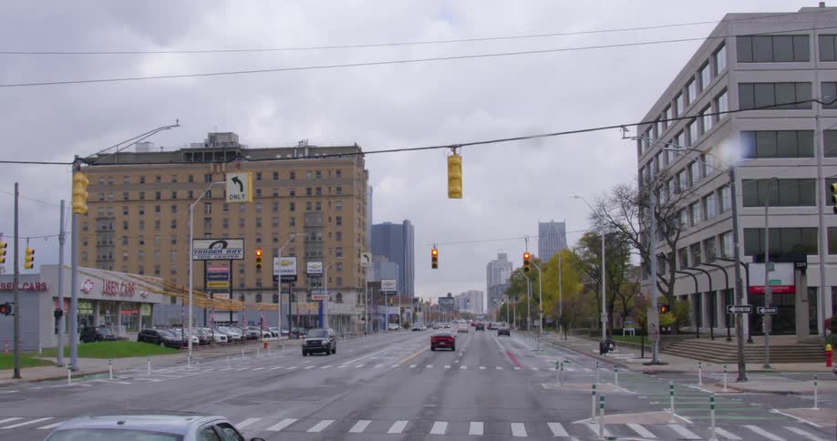 A city street with vehicles with buildings and the sky in the background