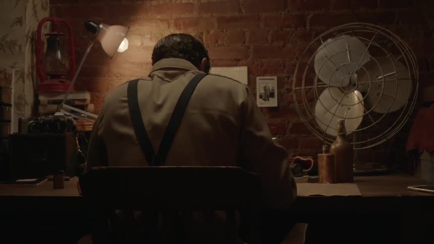 A man is sitting at a desk working on something