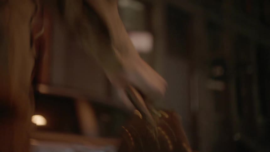 A person holding a briefcase runs down a city street at night