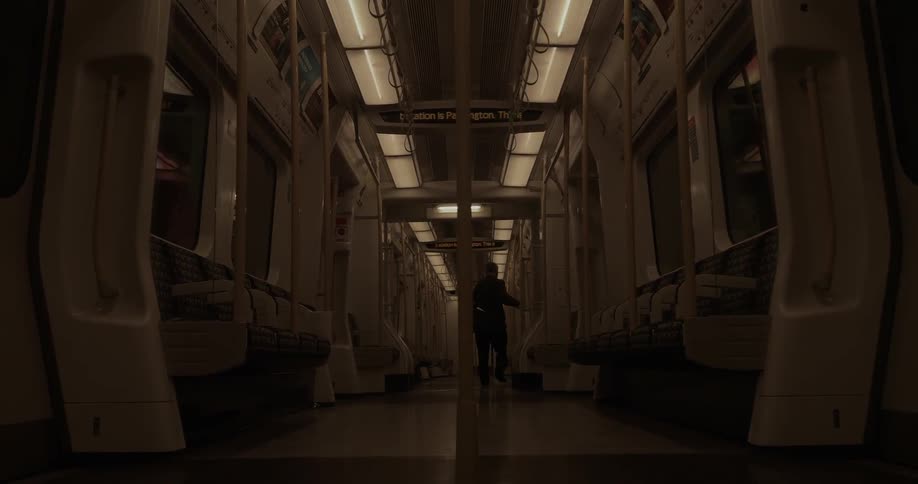 A person walks onto an empty moving train