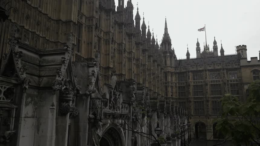 A flag blows in the wind high above the Palace of Westminster