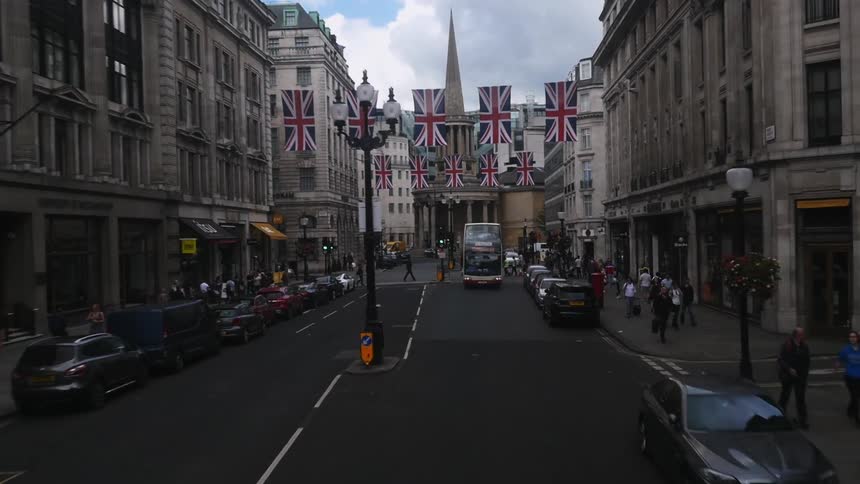 Cars and people travel along a busy city street