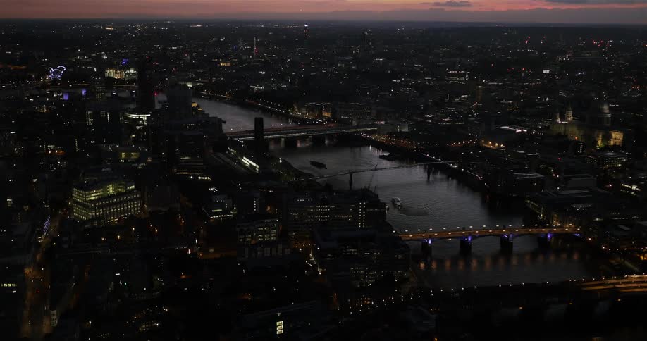Aerial view of a city and two bridges at night
