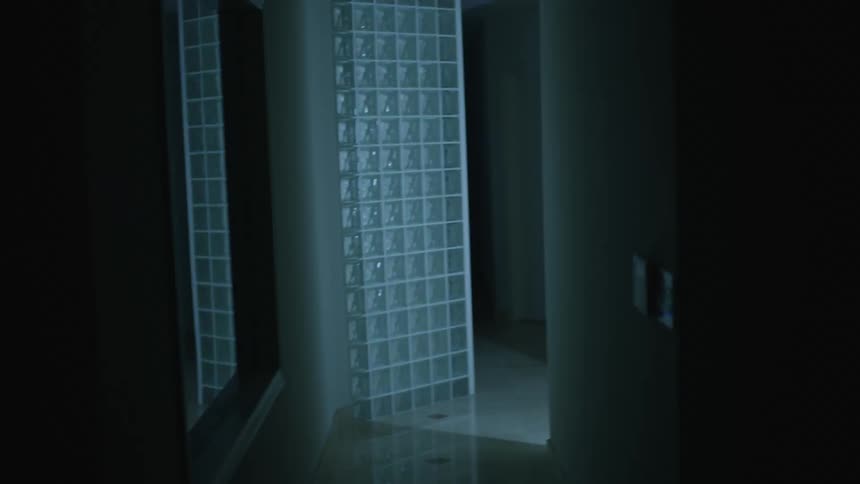 A person with a silver hazmat suit walking in the doorway with lights flashing
