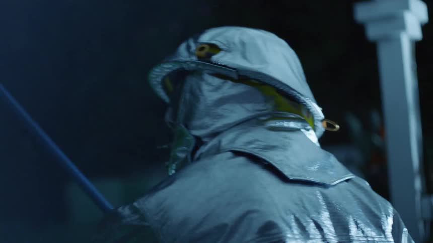 The person in the hazmat suit walks slowly in the dark