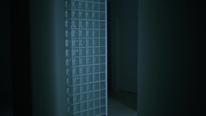 A person with a silver hazmat suit walking into a doorway with blinking lights