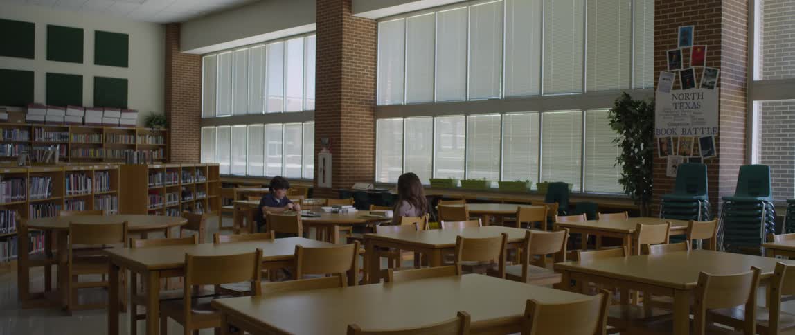 A boy and teacher after school in the library