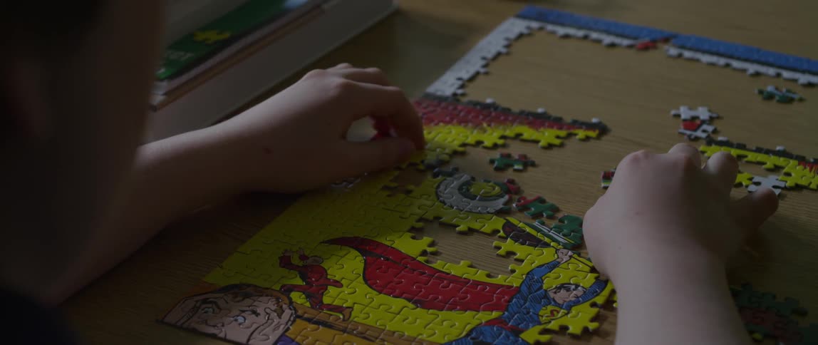 A boy putting puzzle pieces together