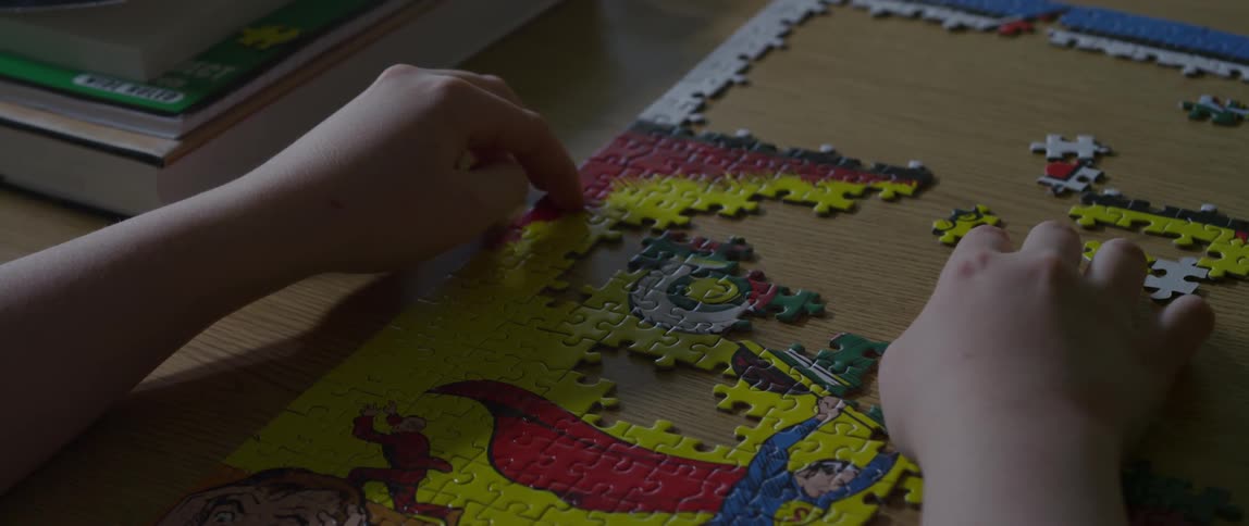 A person is putting puzzle pieces together on a table
