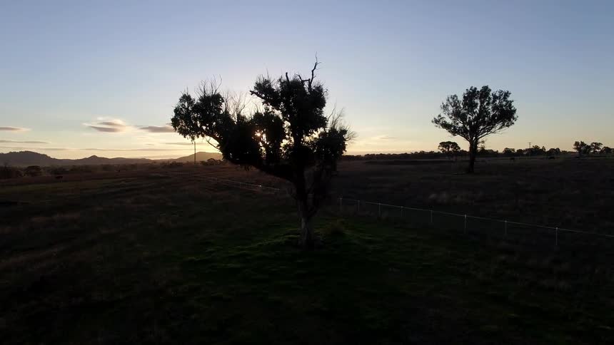 View of fields and mountains as the sun sets
