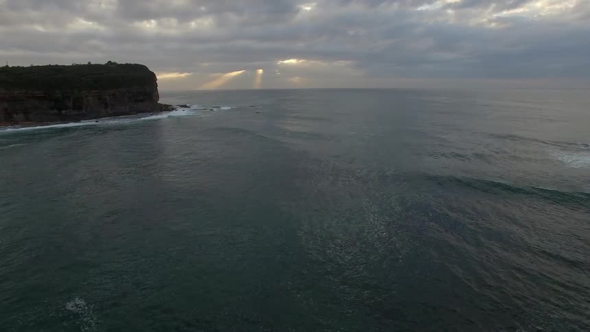 Waves flowing towards shore under storm clouds