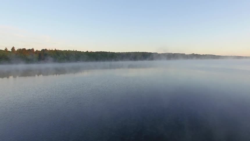 View of a lake with fog on the surface