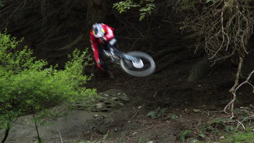 A mountain biker jumps around the trail