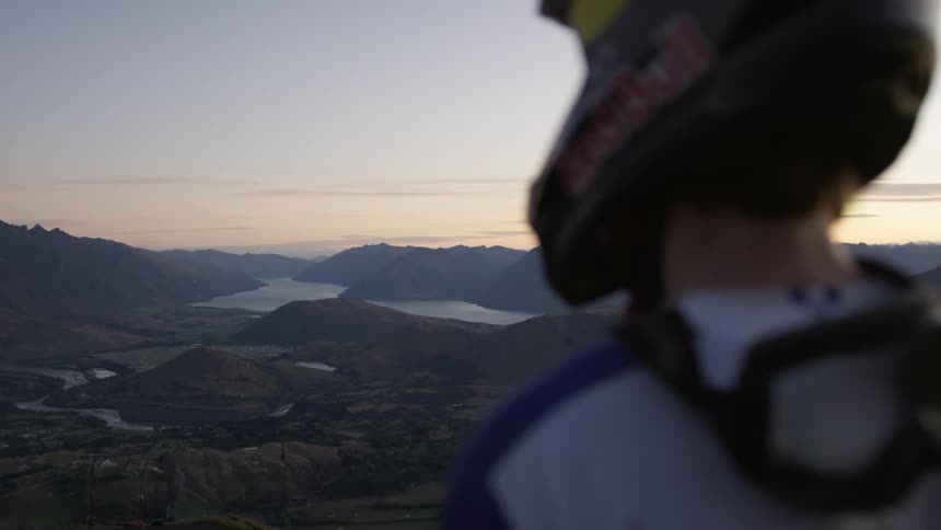 A young man stands and looks across the landscape