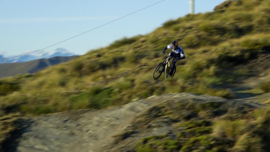 Cyclist drives mountain bike on a dirt road at full speed