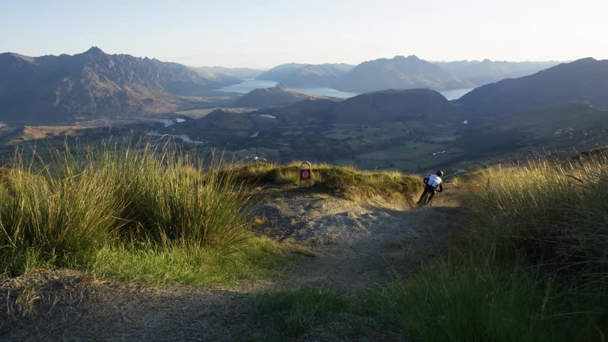 A person jumping on their mountain bike and riding down a hill