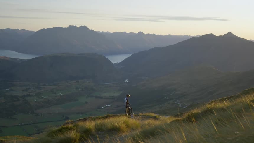 A bicyclist stops while on a trail near a canyon