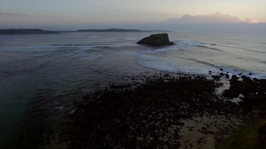 Ocean waves flow towards the shore at sunset