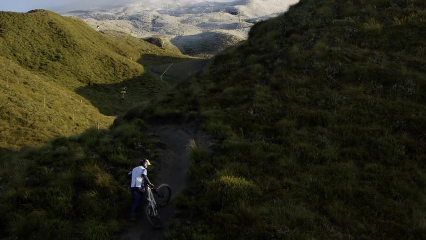 A man lifts his bike on the mountain