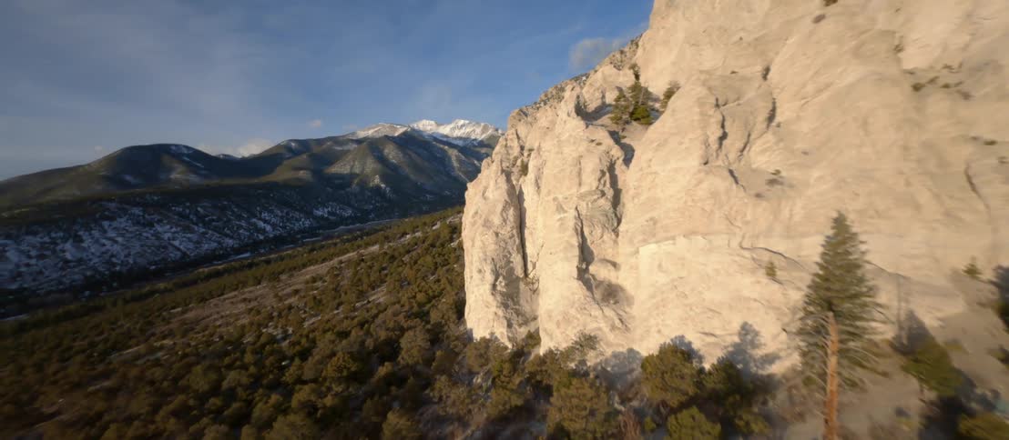 Aerial view of a steep rocky mountain and conifer trees