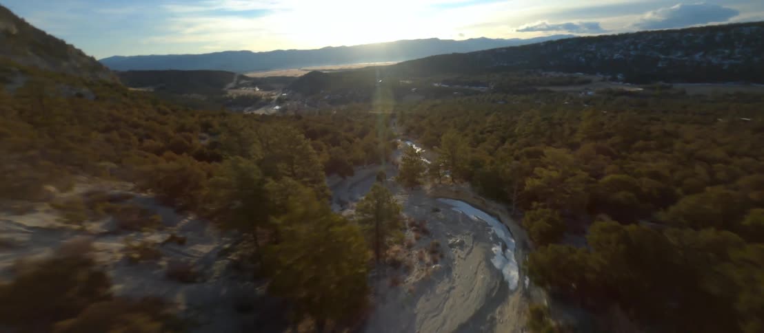 Aerial view of a road running through a mountain range and forest