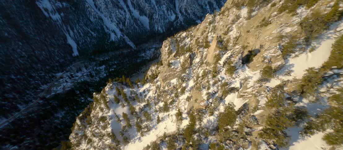 Aerial view of a deep valley between snowy steep mountains