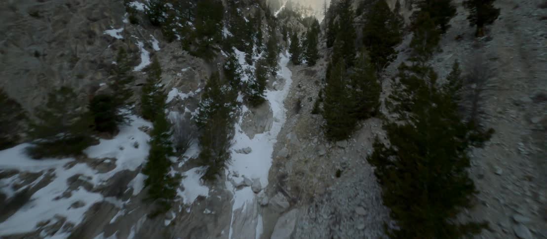 Aerial view of a narrow valley covered with snow between steep mountains