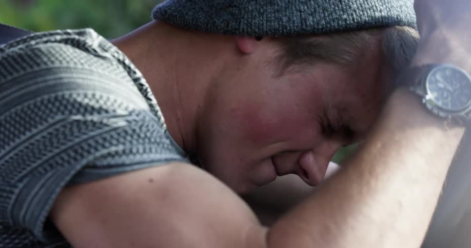 A teenager screams and cries while sitting in his car
