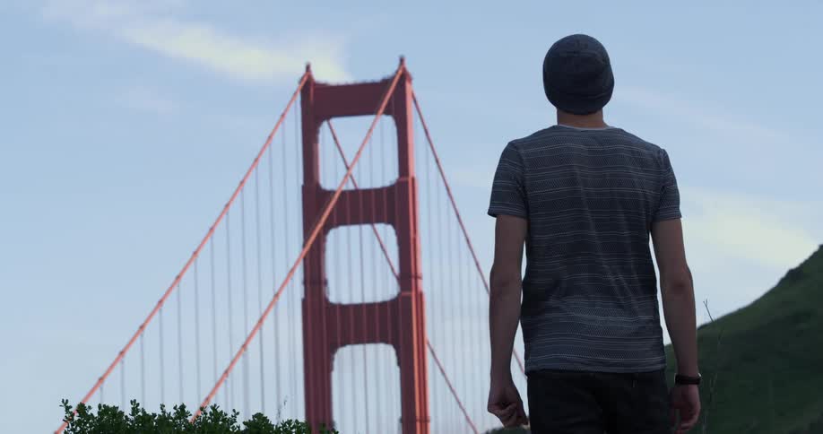 A man stands and looks at the Golden Gate bridge