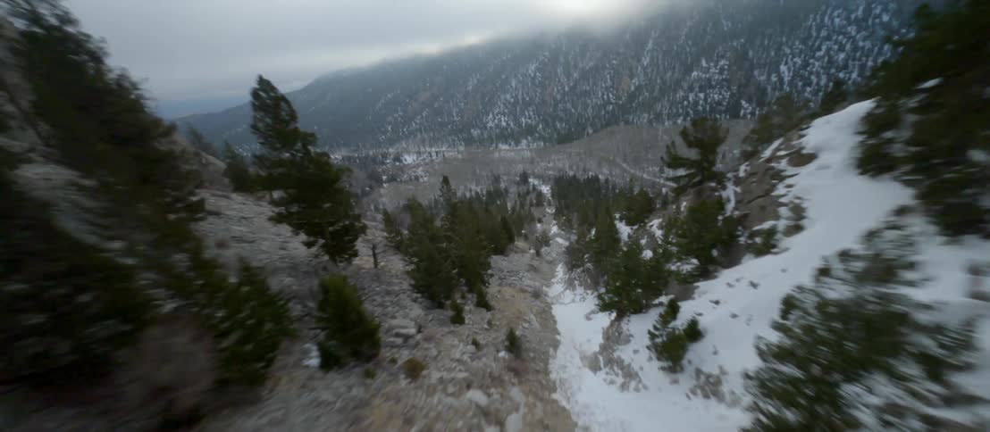 Aerial view of a snow covered mountain pass under the clouds