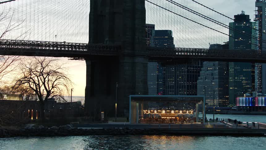 Cars drive over the bridge towards the buildings
