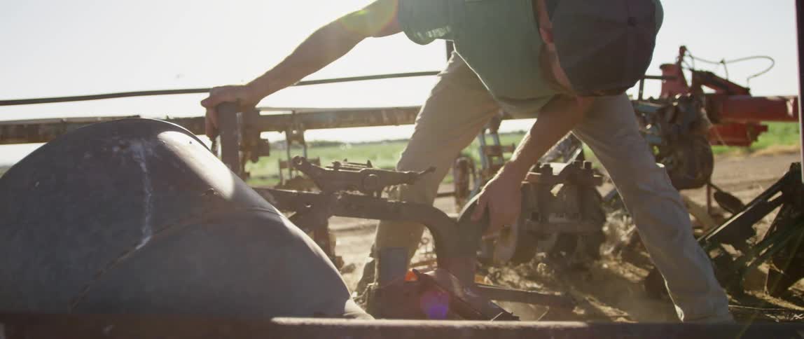 A young man on a farm tries to move some equipment