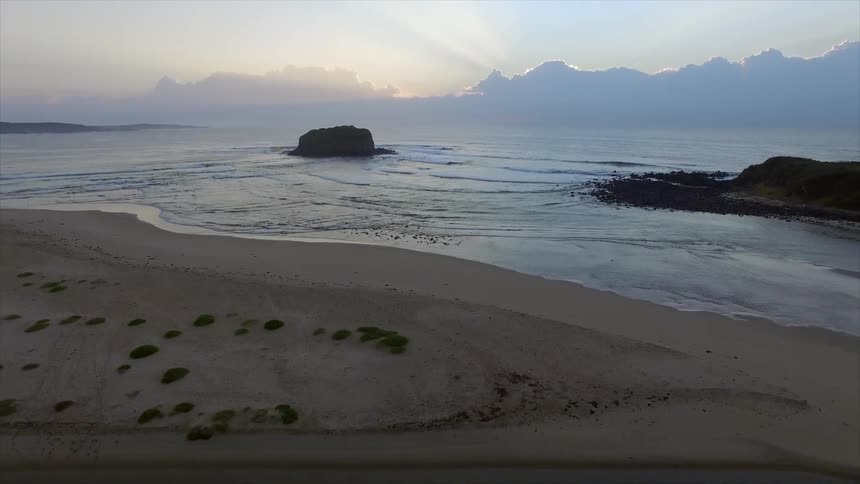 The sun is setting over a beach