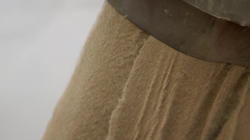 Sand falling out of a tube