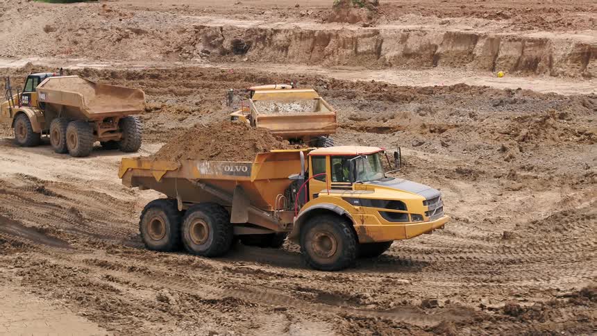 Trucks are driving around a construction site