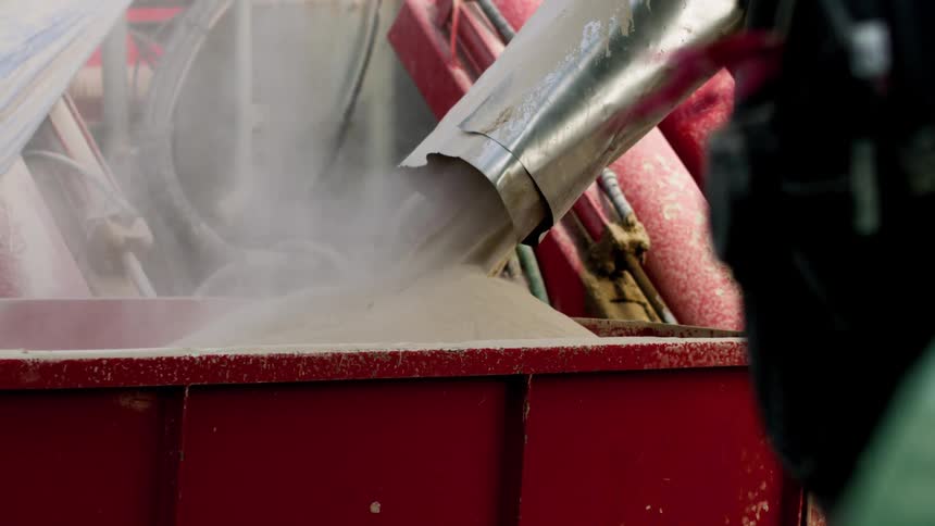 A powder being poured out of a silver bag into a container