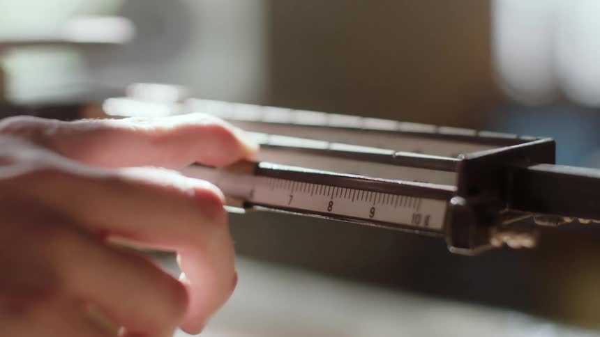 A person moves a scale with the finger