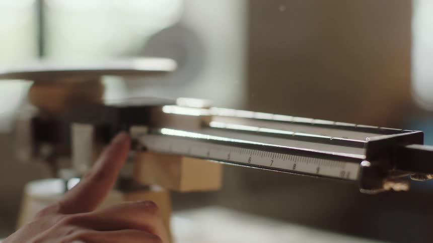 A woman moves the slider on a scale