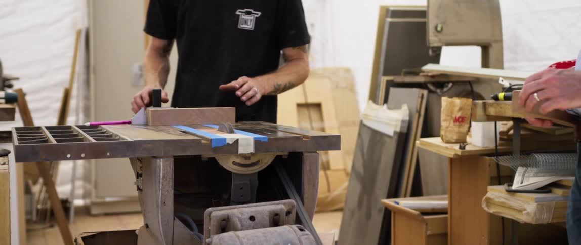 Man prepares a piece of wood to be cut on a circular saw