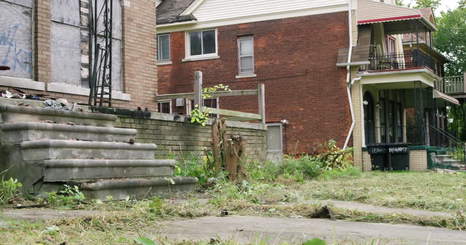Abandoned house in a neighborhood next to a brick house