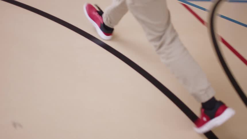 A person running along the free throw circle on a basketball court