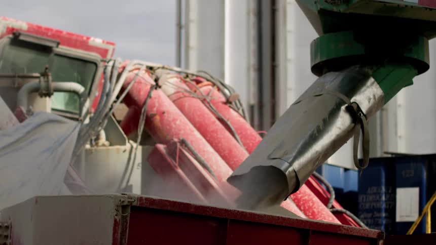 Sand coming out of a chute into a container outside a factory