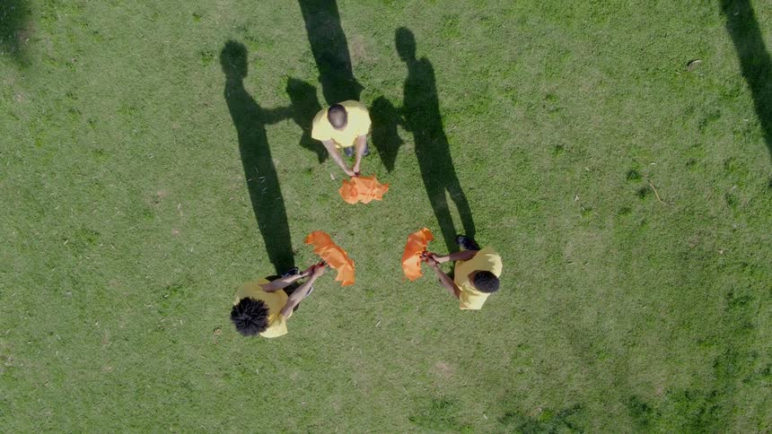 Three people stand together and open and close their umbrellas in unison