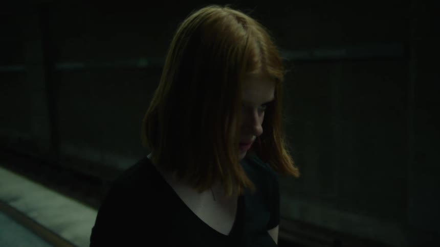 Young woman walking down a dimly lit subway station
