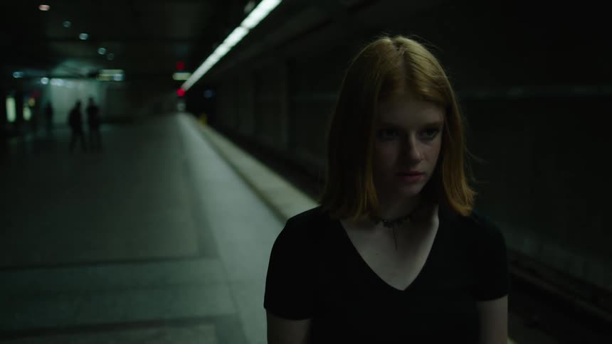 A woman is walking alone at night