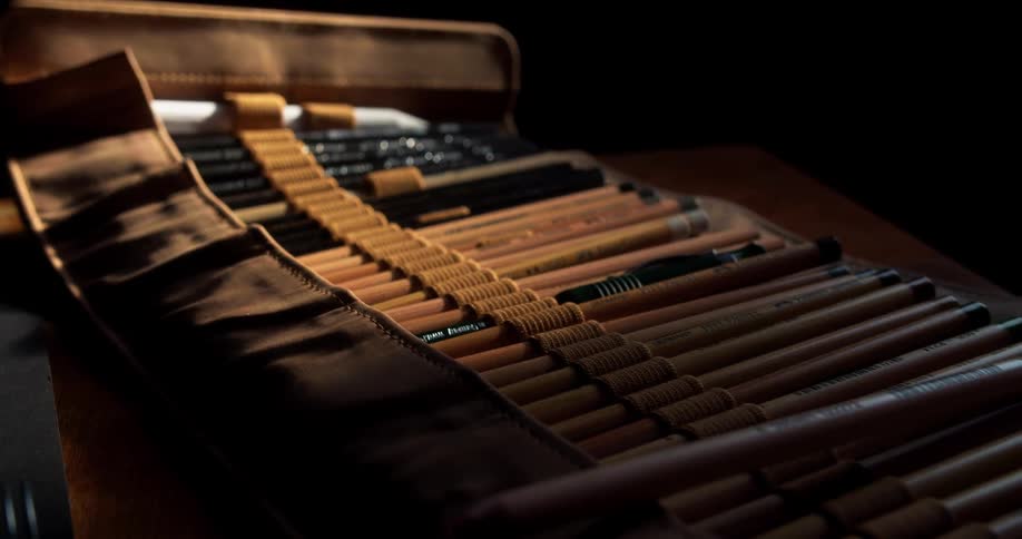 A case of colored pencils and markers sits on a desk