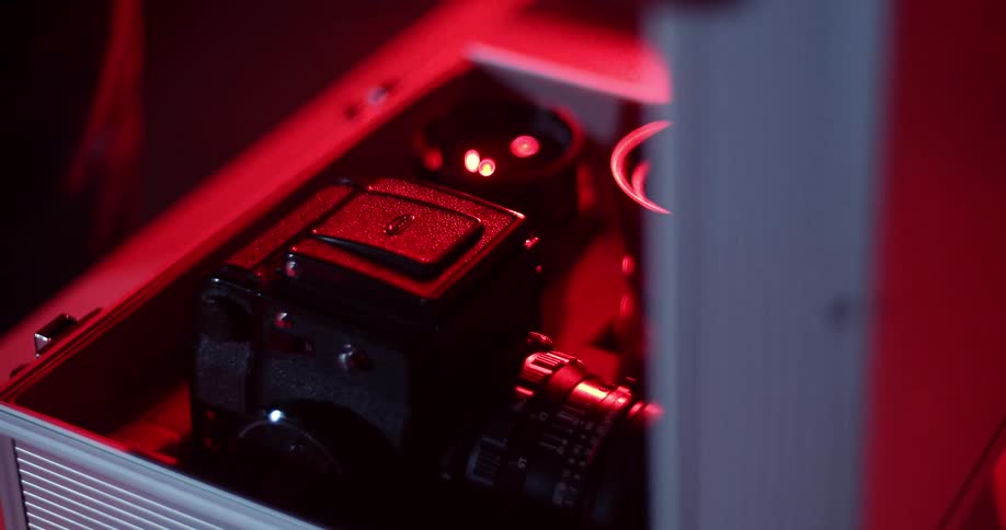 Man places camera inside a metal case inside a dark room